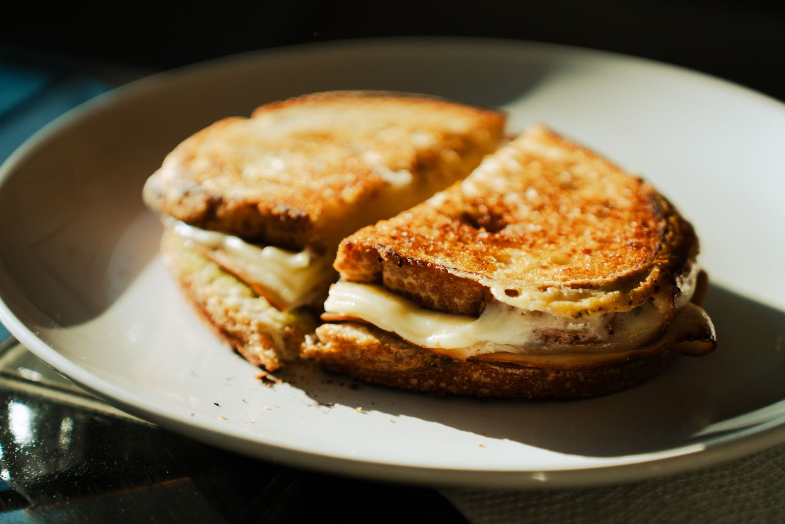 Croque-monsieur doré décoré en chouette avec des légumes disposés dans l’assiette.