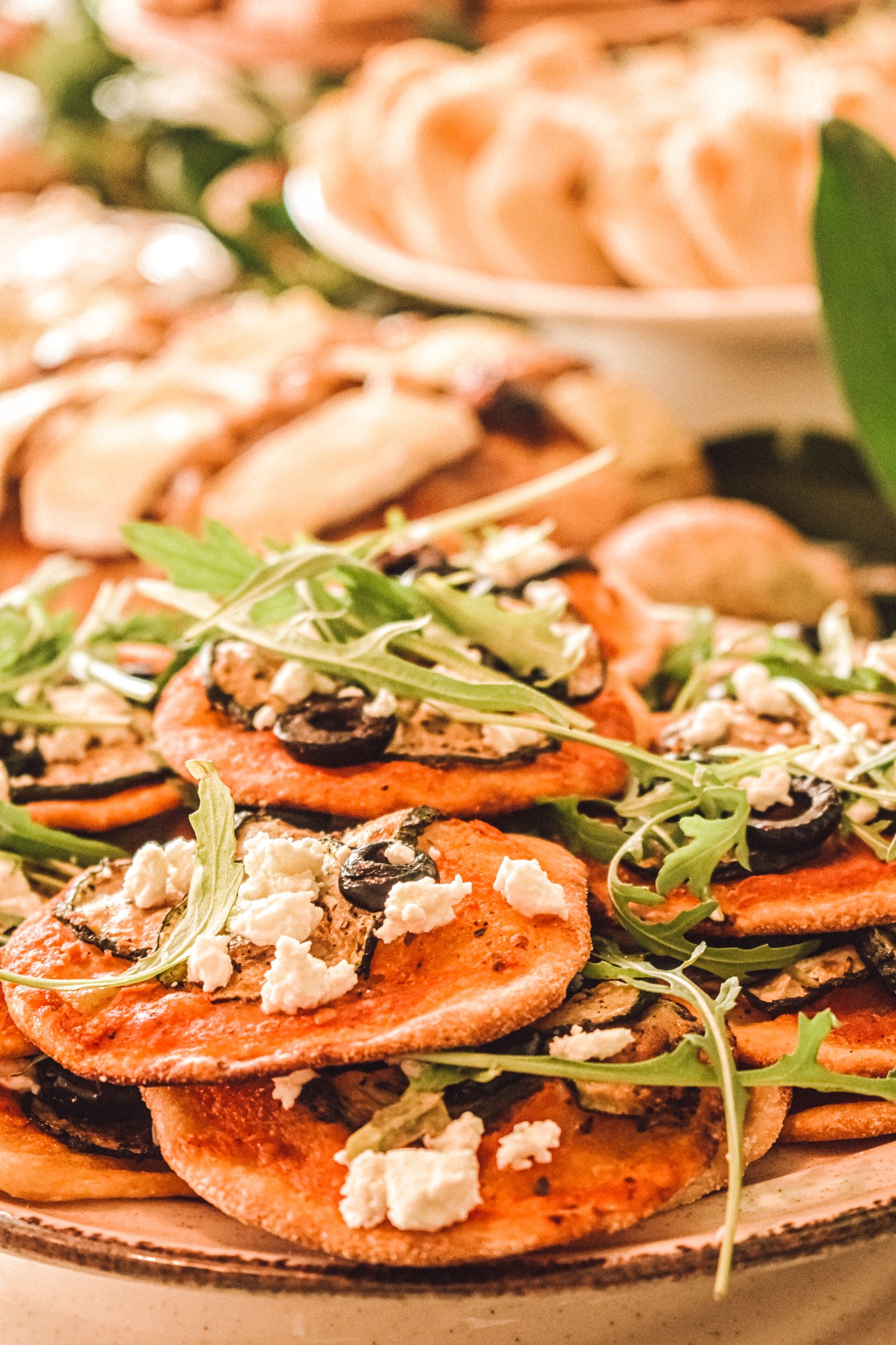 Mini-pizzas dorées au fromage, aux olives et à la roquette.