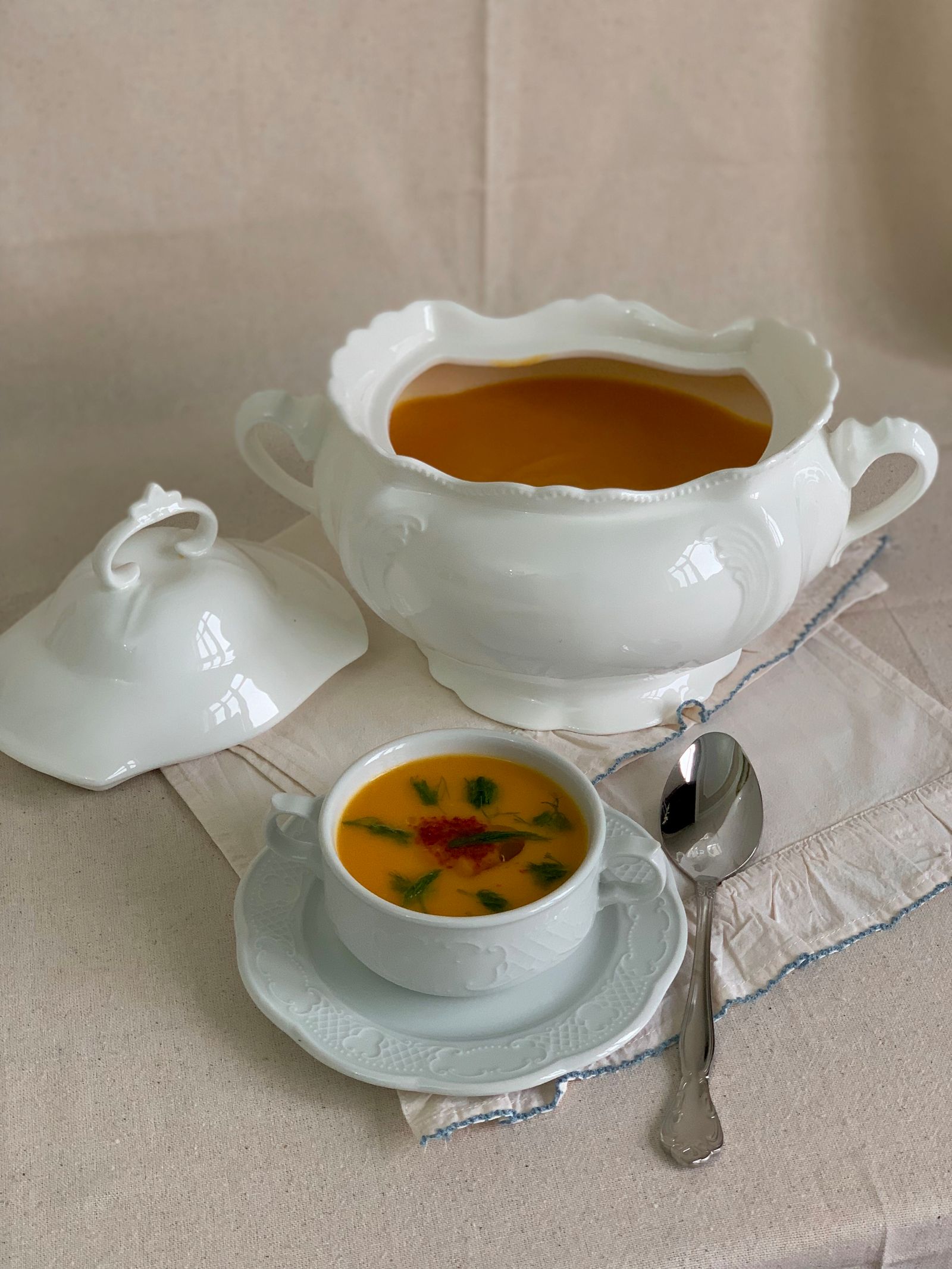 Velouté orange de carotte et patate douce servi dans un bol avec un filet de crème.